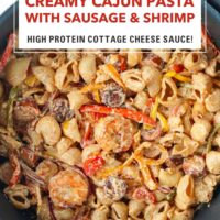 Skillet with creamy shrimp and sausage pasta. Text overlay "Creamy Cajun Pasta with Sausage & Shrimp", "High Protein Cottage Cheese Sauce" and "That Spicy Chick".