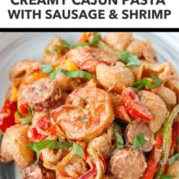 Front view of plate with spicy cottage cheese pasta with shrimp and sausage. Text overlay "High Protein Creamy Cottage Cheese Sauce!", "Creamy Cajun Pasta with Sausage & Shrimp", and "That Spicy Chick".
