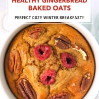 Closeup of spiced baked oats in a white ramekin topped with raspberries and pecans. Text overlay "Healthy Gingerbread Baked Oats", "Perfect Cozy Winter Breakfast!" and "That Spicy Chick".