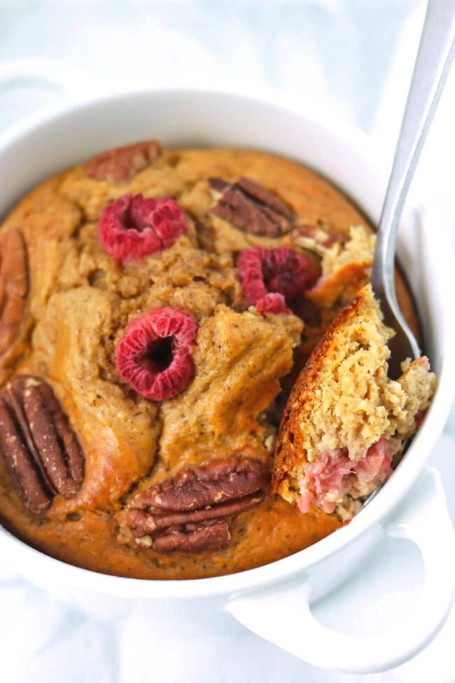Spoon in ramekin taking out a bite of gingerbread baked oats.