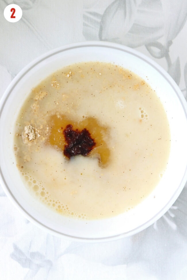 Almond milk, unsweetened applesauce, egg whites, and molasses added to bowl with dry ingredients for gingerbread baked oats.