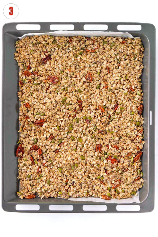 Pecan pie granola mixture on parchment paper lined baking tray.