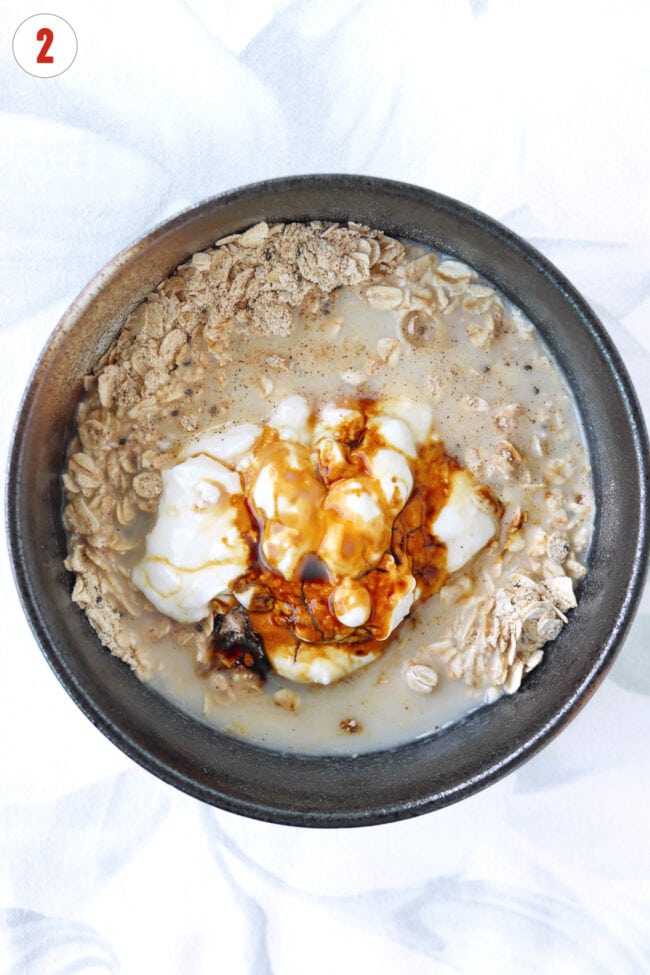 Greek yogurt, molasses and almond milk in bowl with oats, protein powder, spices and chia seeds.