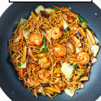 Stir-fried noodles with shrimp, vegetables and tofu in a large wok. Text overlay "Shrimp Yakisoba with Five Spice Tofu" and "That Spicy Chick".