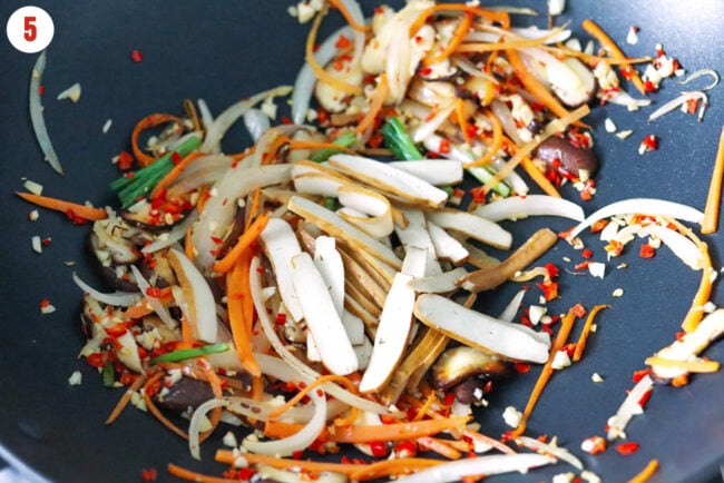 Sliced five spice tofu and vegetables in a wok.