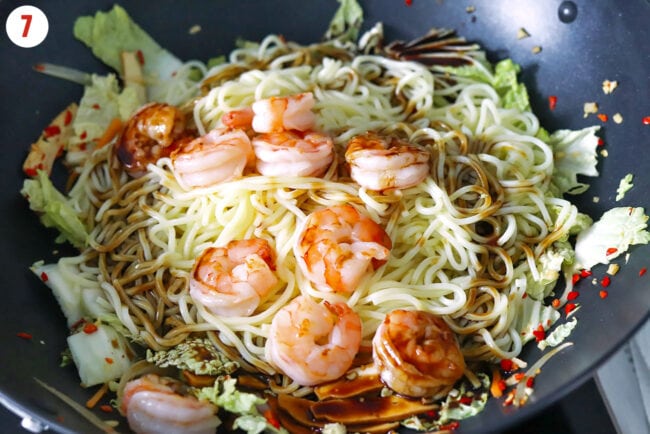 Shrimp, yakisoba noodles, and yakisoba stir-fry sauce in a wok with stir-fried vegetables and tofu.