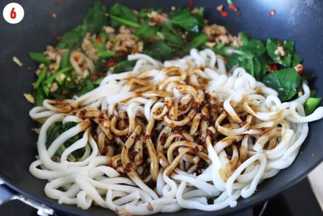 Added udon noodles and chili oil stir-fry sauce to wok with stir-fried veggies, ground pork and aromatics.
