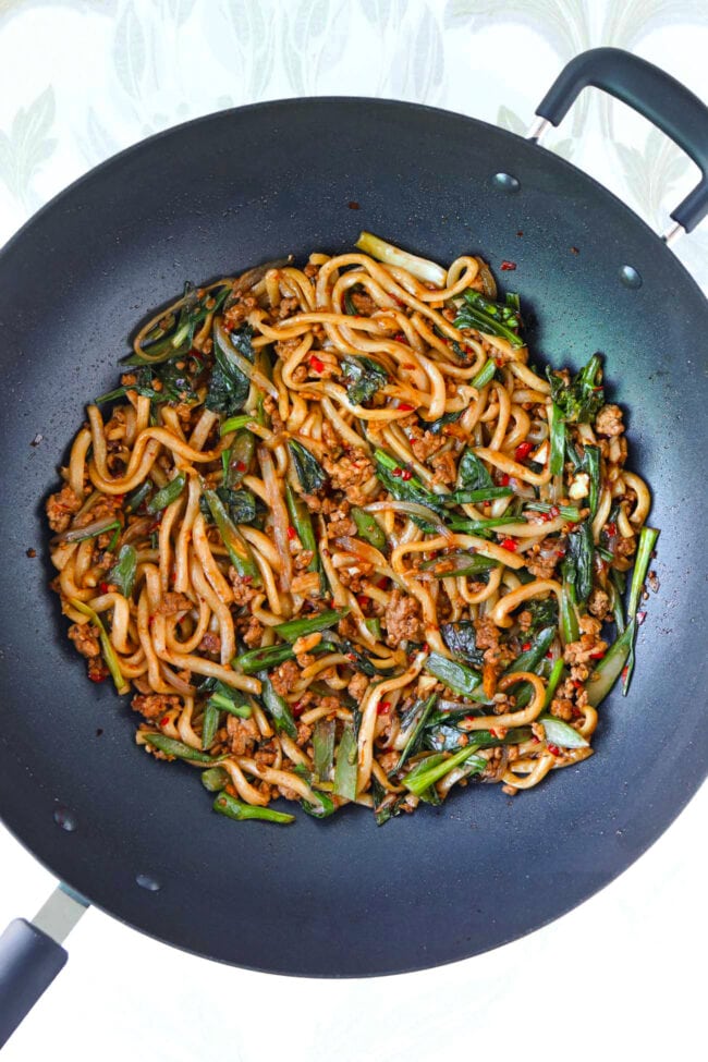 Sichuan Pork and Broccoli Noodles in a black wok.