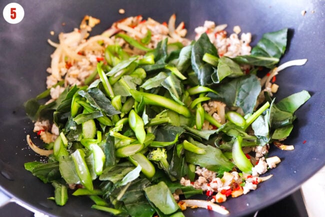 Added sliced Chinese broccoli to wok with stir-fried veggies and pork.