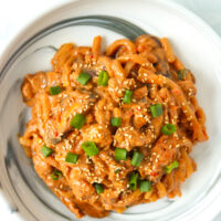 Top view of plate with creamy kimchi udon noodles with blended tofu sauce.