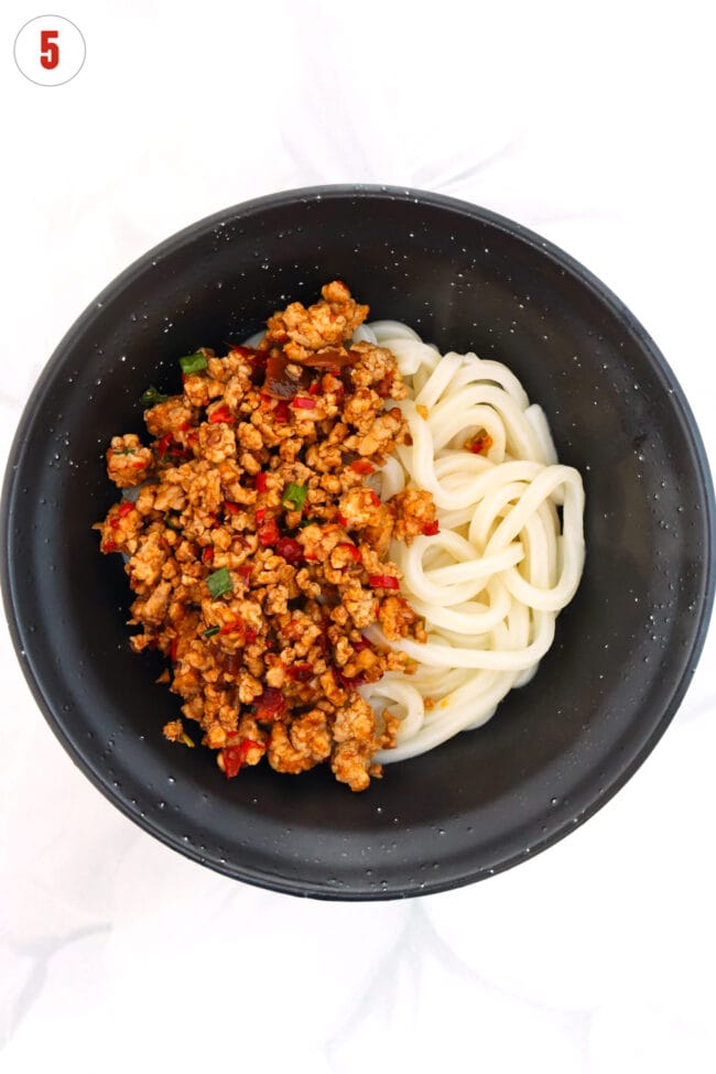 Mapo seasoned ground pork and udon noodles in a black bowl.