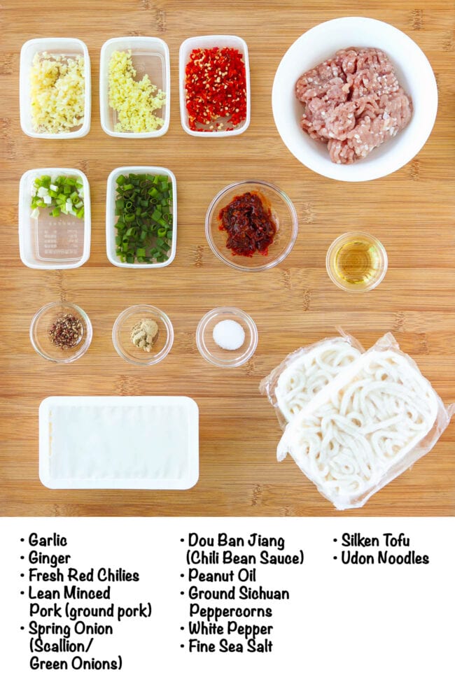 Labeled ingredients for Creamy Mapo Tofu Pork Noodles on a wood board.