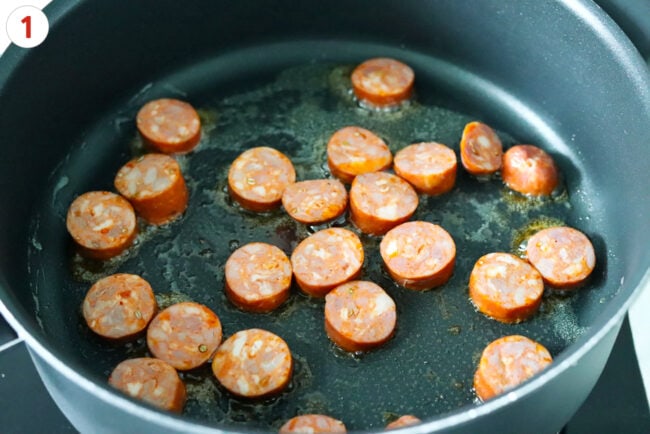 Searing sliced sausage in a skillet.
