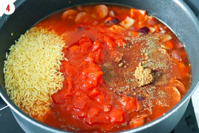 Orzo, diced tomatoes, roasted chicken bouillon broth base and seasonings in a pan.