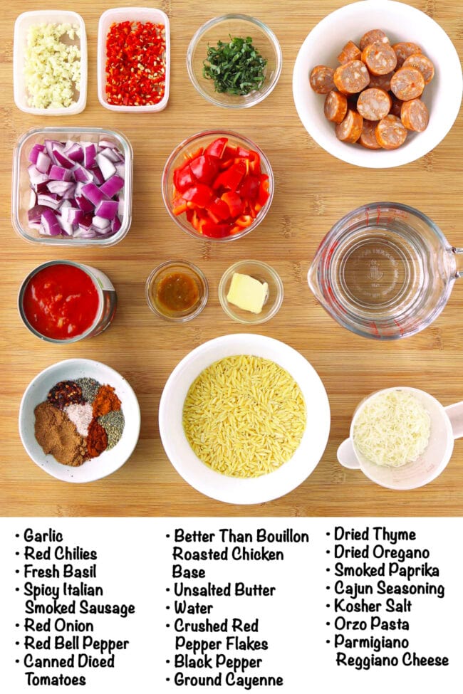 Labeled ingredients for One Pan Cajun Orzo with Sausage on a wood board.