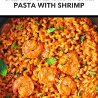 Closeup of Calabrian chili pasta and shrimp in a nonstick skillet. Text overlay "Easy Romantic Pasta Dinner!" and "Creamy Calabrian Chili Pasta with Shrimp".