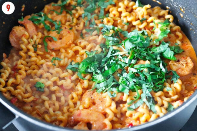 Added basil to pan with shrimp and creamy Calabrian chili pasta.