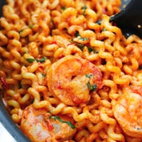 Closeup of creamy Calabrian chili pasta with shrimp in pan.