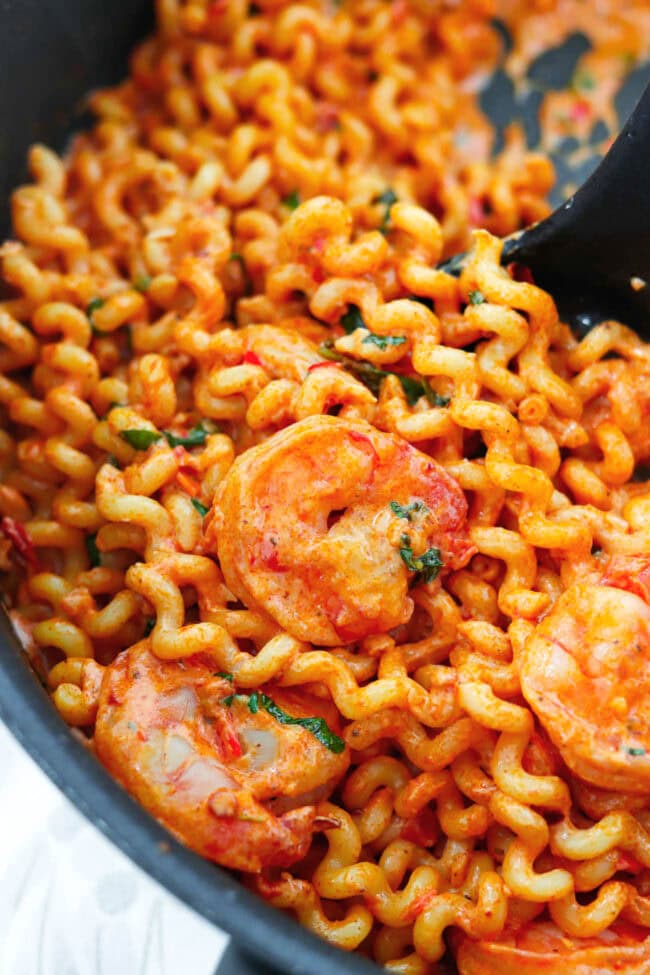 Closeup of creamy Calabrian chili pasta with shrimp in pan.