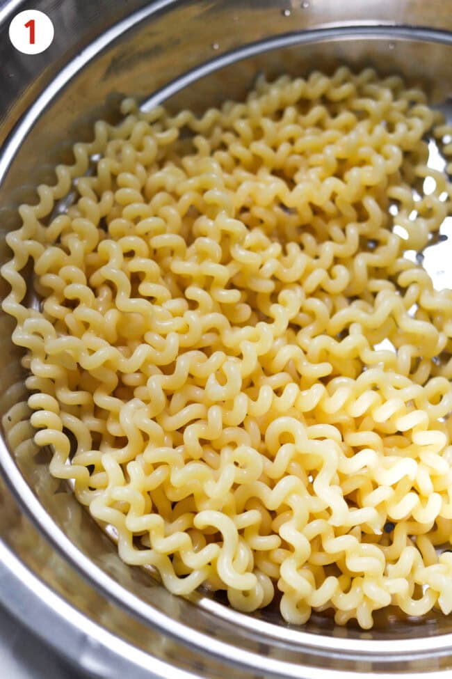 Cooked and drained fusilli lunghi bucati pasta in a colander.