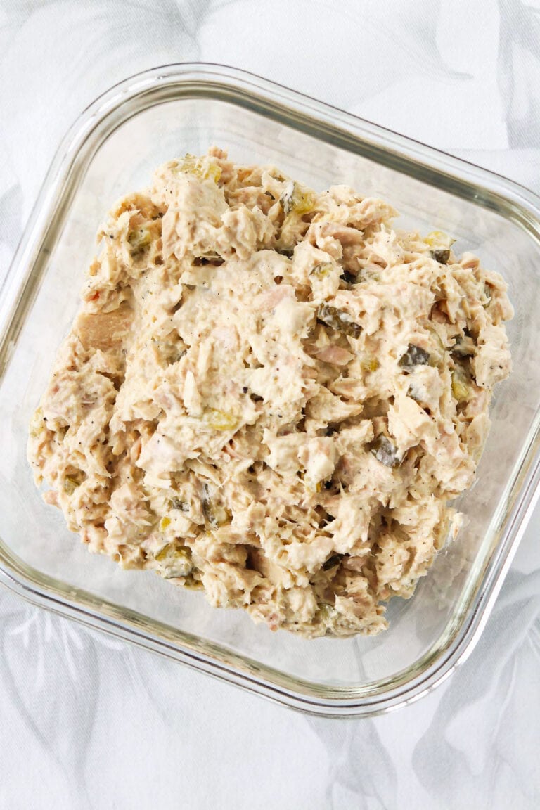 Cottage cheese tuna salad with dill pickles in a square glass meal prep dish.