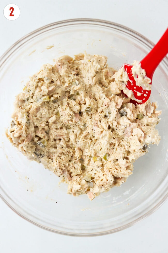 High protein tuna salad with dill pickles in a bowl with a silicone spatula.