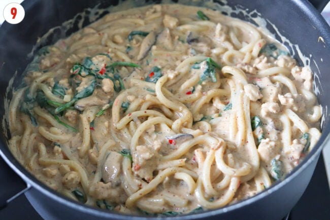 Creamy mushroom udon noodles with ground chicken, mushrooms, spinach and a blended silken tofu sauce in a pan.