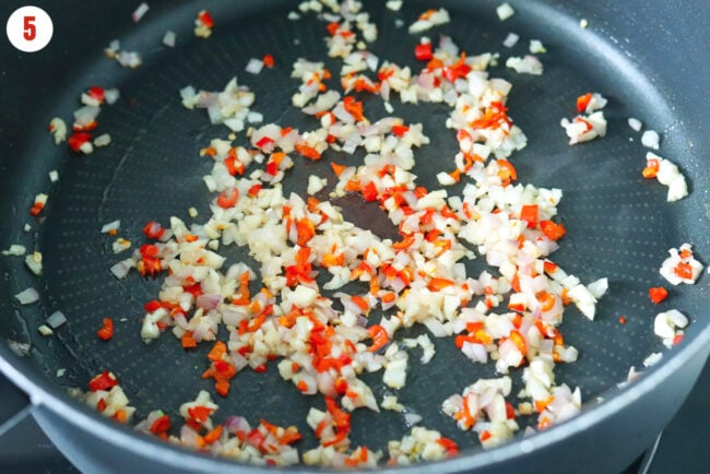 Sautéed shallots, garlic and chilies in butter in a pan.