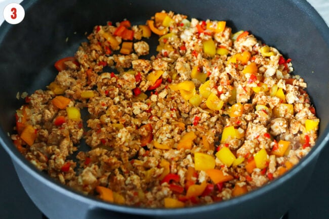 Cooked taco seasoned ground chicken, sweet peppers, onion, garlic and chilies in skillet.