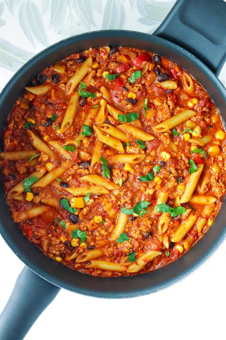 Skillet with high protein chicken taco pasta with cottage cheese topped with chopped cilantro.