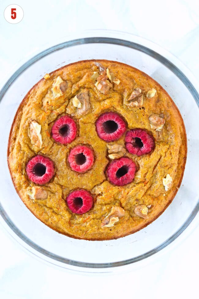 Baked carrot cake protein pancake bowl with raspberries and chopped walnuts.