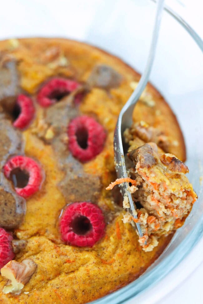 Closeup of spoon taking out a bite of carrot cake protein pancake from a meal prep container.