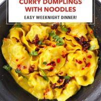Black bowl with curry dumplings and noodles topped with chili crisp and coriander. Text overlay "Curry Dumplings with Noodles", "Easy Weeknight Dinner!" and "That Spicy Chick".