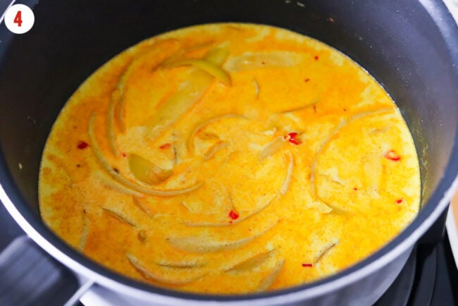 Coconut milk curry sauce with onion, garlic and chilies in a pot.