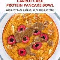 Carrot cake pancake in a round glass meal prep container topped with chopped walnuts, raspberries, maple syrup, and pecan butter. Text overlay "Carrot Cake Protein Pancake Bowl", "With Cottage Cheese | 40 Grams Protein!" and "That Spicy Chick".