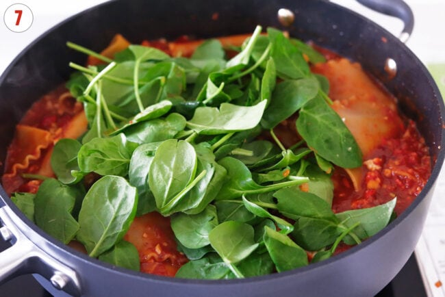 Baby spinach in pan with vodka sauce lasagna.