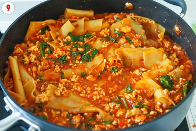 Stirred in sliced basil in pan of vodka sauce lasagna with cottage cheese.
