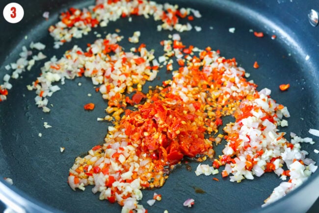Calabrian chili pepper paste in pan with sautéed shallots, garlic, and chilies.