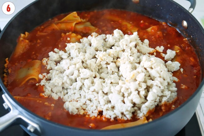 Cooked ground chicken added to pan with cooked lasagna noodles in spicy vodka sauce.