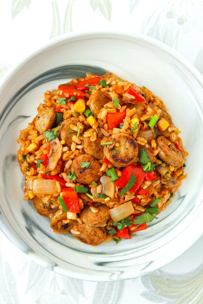 Top view of plate with seared chicken sausage and rice dish.