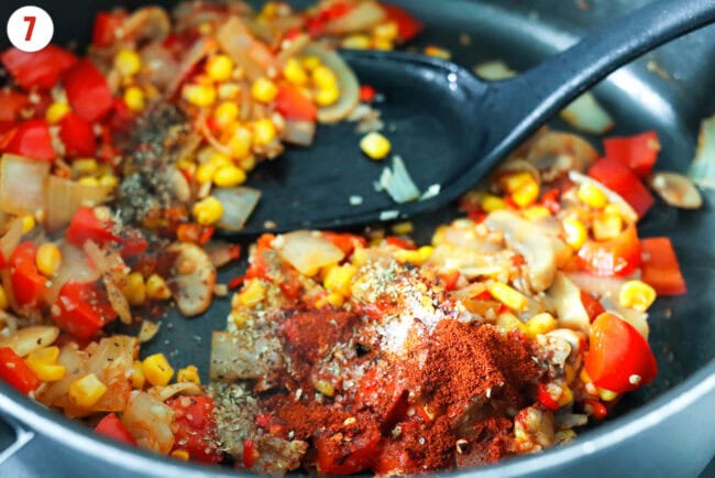 Seasonings added to skillet with sautéed corn, onion, mushrooms, garlic, chilies, and red bell pepper.