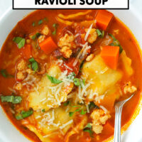 Spicy ravioli soup with ground chicken topped with grated parmesan and sliced basil in a bowl with a spoon. Text overlay "Spicy Vodka Ravioli Soup" and "That Spicy Chick".