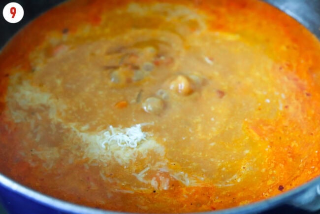 Grated parmesan added to pot with spicy vodka soup.