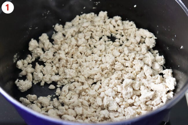 Cooked lean ground chicken in a large Dutch oven.