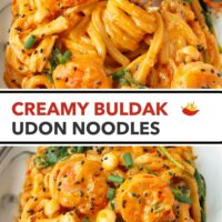 Fork in plate with creamy spicy Korean udon noodles with shrimp topped with black sesame seeds and green onions. Text overlay "Creamy Buldak Udon Noodles"