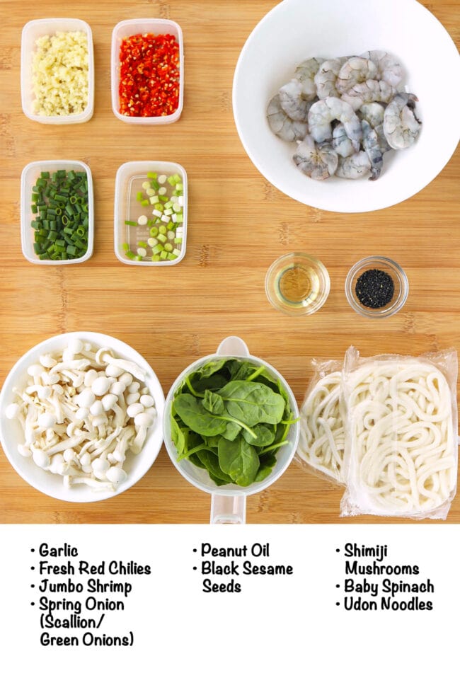 Labeled ingredients for Creamy Buldak Udon Noodles on a wood board.