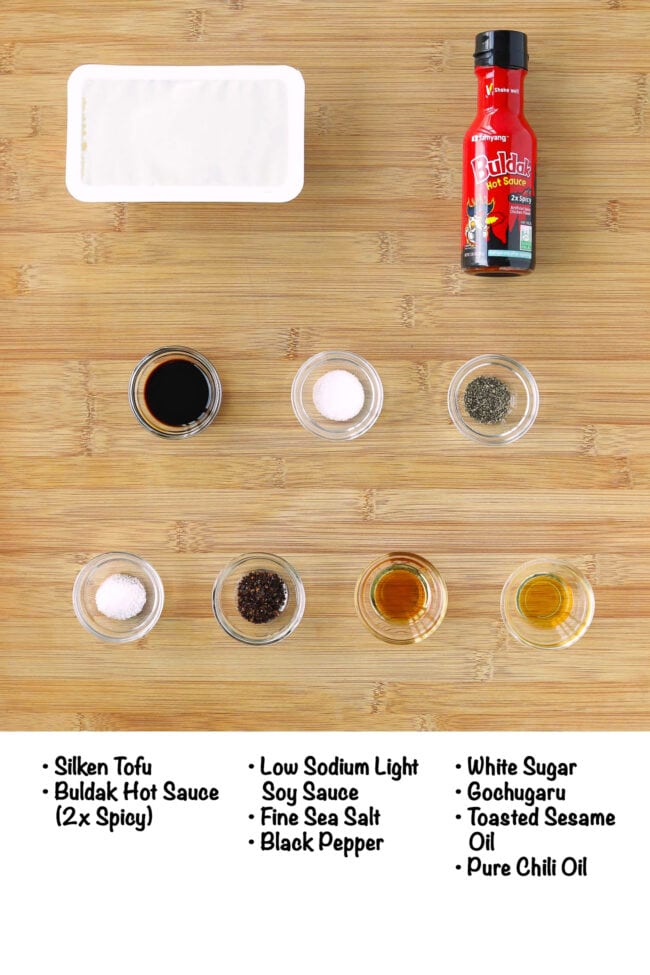 Labeled ingredients for silken tofu buldak sauce on a wood board.