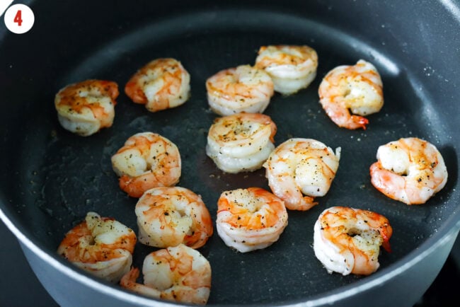 Seared shrimp with salt and pepper in a pan.