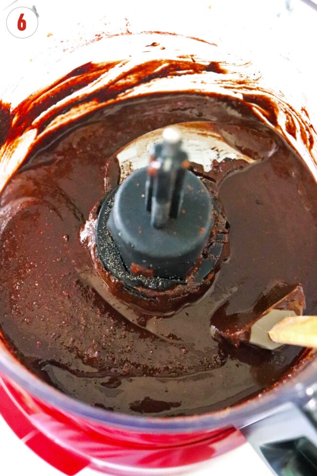 Dark chocolate pecan butter in a food processor bowl with a spatula.