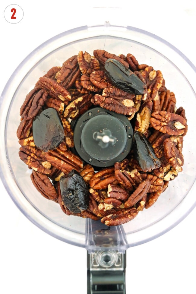 Roasted pecans and dates in a food processor bowl.